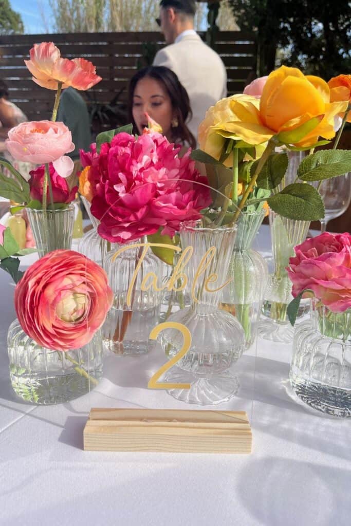 bud vase table decor for wedding - orange, pink and yellow flowers in clear bud vases 