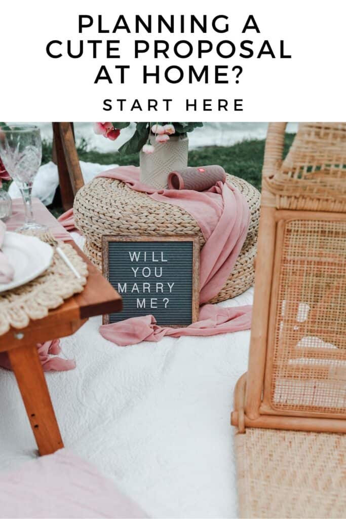 romantic at home proposal with picnic blankets and sign 