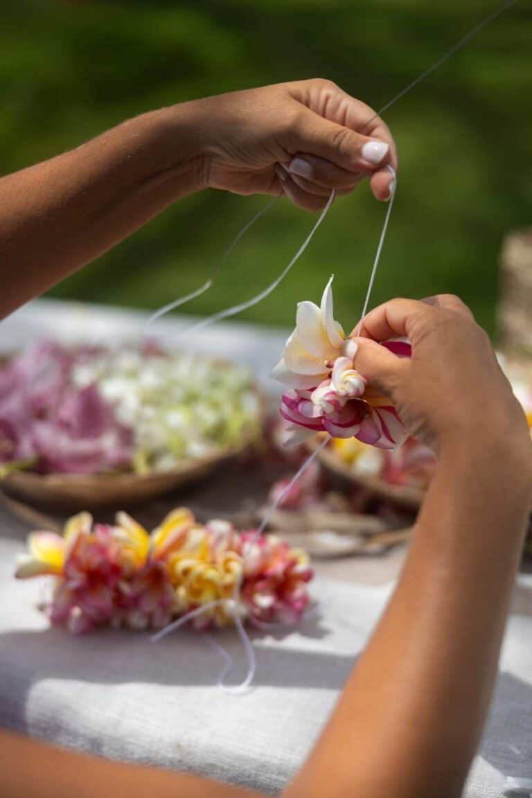 DIY flower crown station - womans hands at a table threading flowers