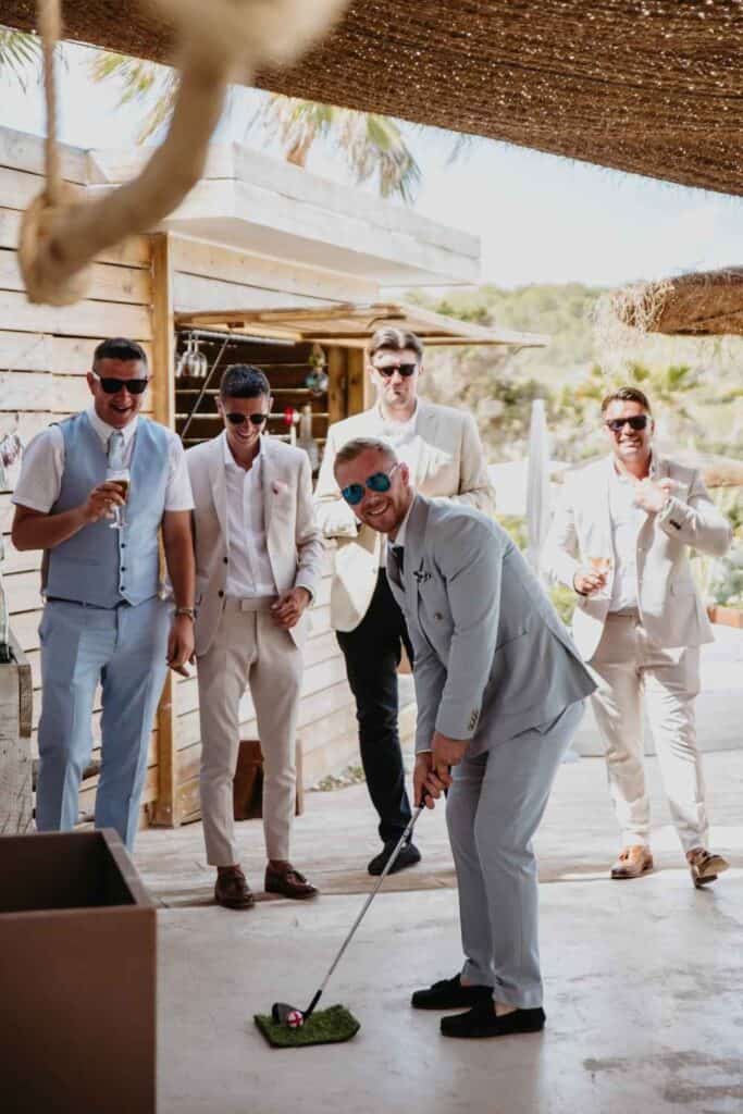 mini golf backyard wedding game. Man putting with gold club outisde