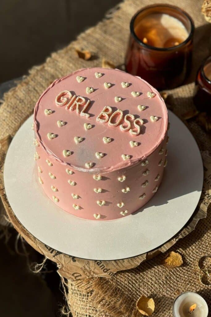 valentines cake decorating - pink cake with girl boss in white icing 