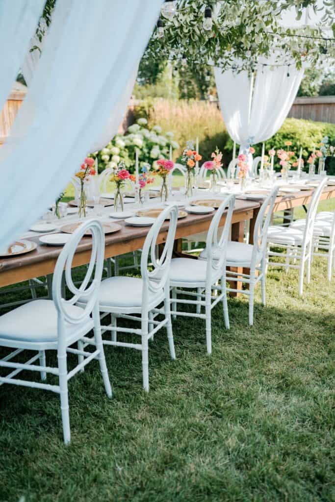 backyard wedding decor white tables with colorful florals 