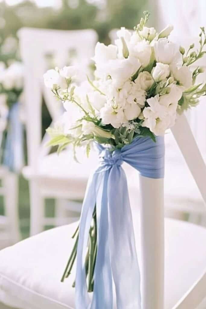 dusty blue ribbon with white flowers on ceremony chairs