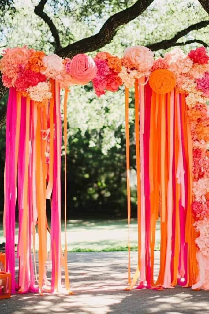 pink and orange streamer wedding arch